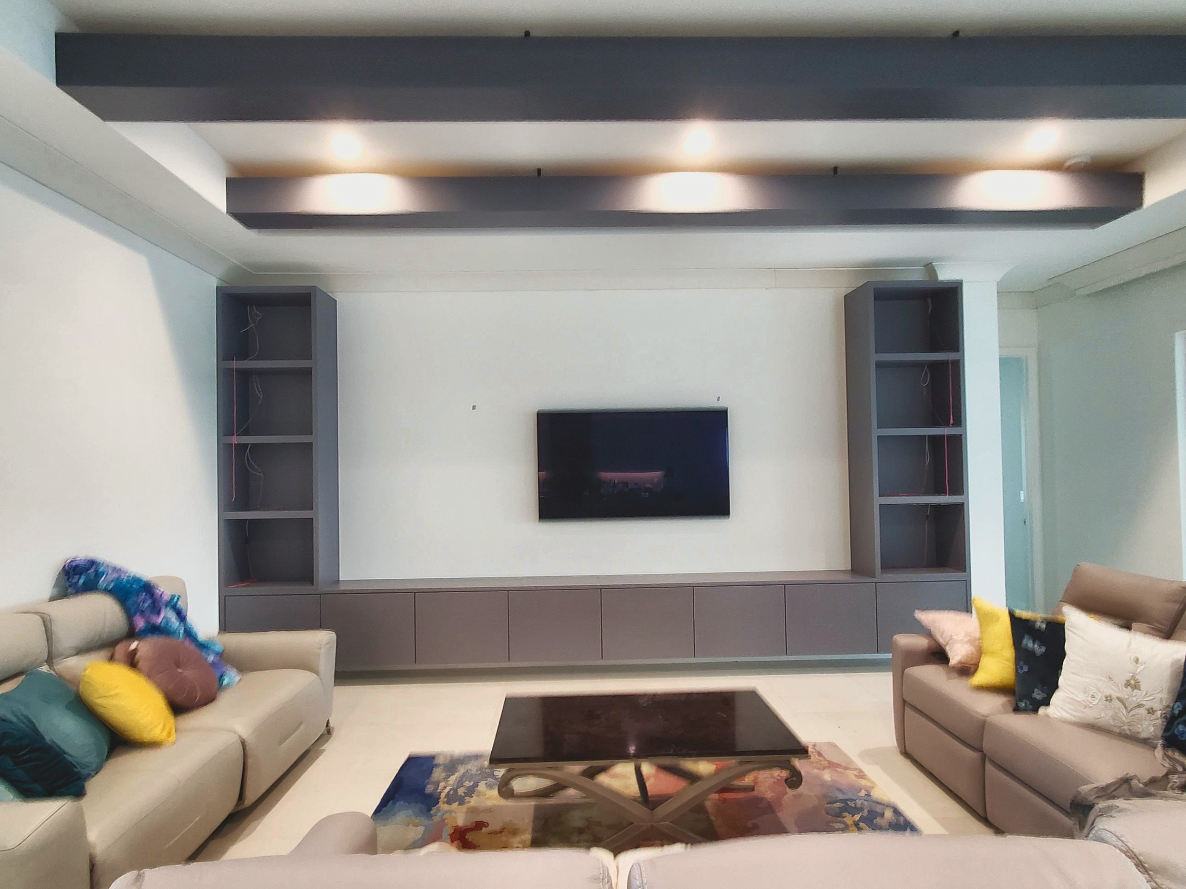Grey media wall with ceiling beams